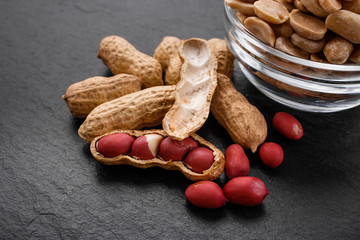 fresh peanuts on a dark stone background