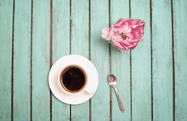 Pink terry tulip, cup of coffee and silver spoon on rustic wooden background, Valentines Day, Mothers day background, good morning concept, top view.