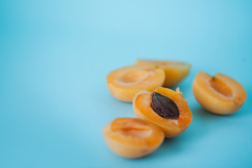 Fresh delicious apricots on a blue background.