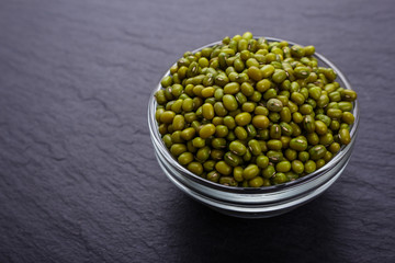 fresh Mung beans on a dark stone background