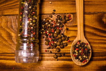 Pepper mill and scattered spices on the wooden table. Top view