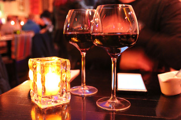 Two glasses of wine with a candle in a restaurant bar