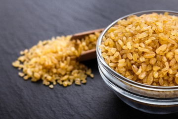 raw bulgur on a dark stone background