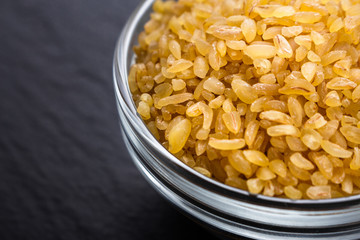 raw bulgur on a dark stone background