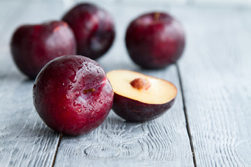 plums on wooden background with a glass of wine