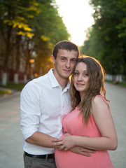 Obraz premium Happy pregnant couple at sunset