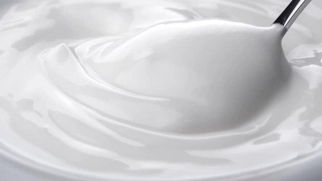 Closeup shot of mixing yogurt with spoon, Rotating

