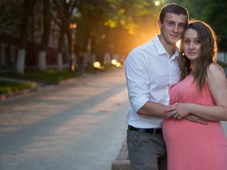 Naklejka premium Happy pregnant couple at sunset