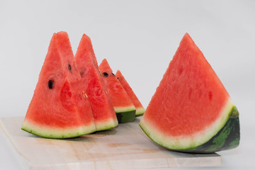 Sliced red watermelon on a wooden cutting board. Isolated.