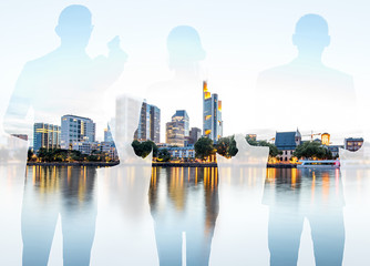 Silhouettes of business people standing back on the modern cityscape background with skyscrapers in...