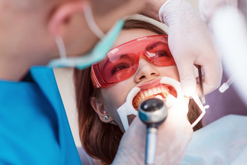 doctor orthodontist performs a procedure for cleaning teeth