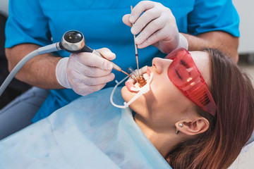 doctor orthodontist performs a procedure for cleaning teeth