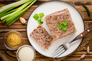 Jelly with meat, beef aspic, traditional Russian dish, portion on plate, mustard and horseradish