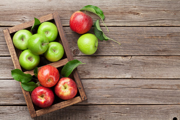 Green and red apples in wooden box
