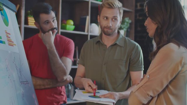 Creative businessman explaining idea to skeptical colleagues. Business people working in office. Marketing team brainstorming session. Casual marketer explain business strategy on business meeting