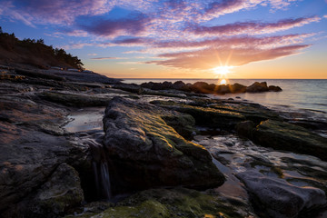 Obraz premium Stones waterfall and cliffs at the sea