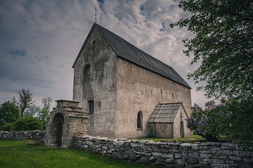 Fototapeta na wymiar Old stone church with stone wall