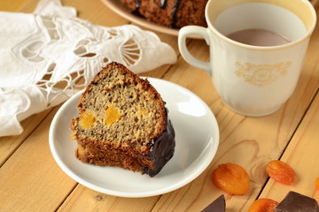 Banana fruitcake with dried apricots in chocolate glaze