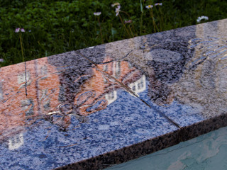 Reflection of buildings in a wet granite slab