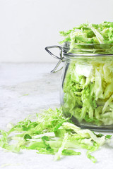 Cut organic cabbage slices in jar on light background