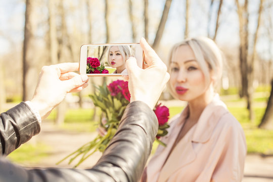 Photographer making photo with smartphone. Phone display with fashion photo young woman