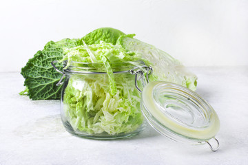 Cut organic cabbage slices in jar on light background