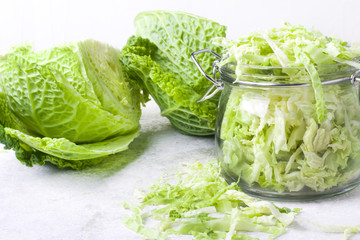 Cut organic cabbage slices in jar on light background