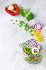 Obraz na płótnie Canvas Healthy homemade vegetable salad in mason jars on white light background
