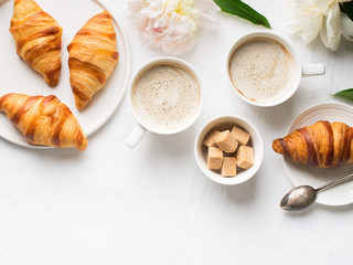 Breakfast on white flat lay with coffee and croissants