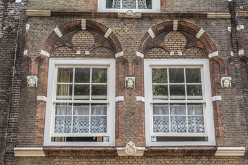 Fototapeta na wymiar Traditional Dutch white lace curtains behind two ancient windows