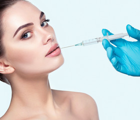 woman's face with fresh perfect skin, a prick of a syringe for the beauty and youth of the face....