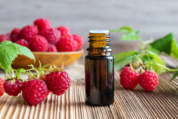A bottle of raspberry seed oil with fresh raspberries