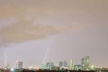 Naklejka na ściany i meble Thunder on rain cloudy sky with city view at night time located at Bangkok Thailand