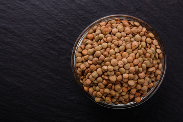 raw lentils on a dark stone background