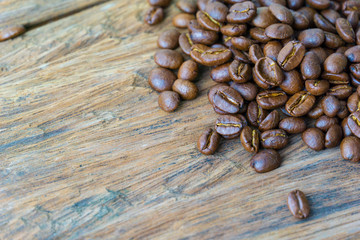 close up of medium or dark roasted coffee bean on the grunge wood surface. copy space for text.
