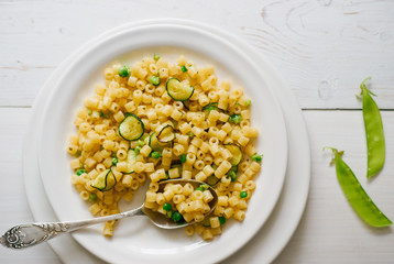 Healthy organic homemade Italian vegetable pasta with zucchini and peas top view