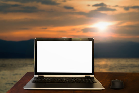 Laptop on a white desk in front of crystal blue sea - Enjoying summer concept © tomispin