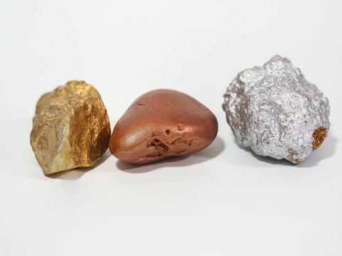 gold, bronze and silver nugget precious stone on white background