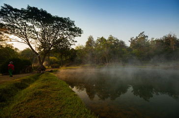 A natural fountain of clear water in morning time with cloudy foggy located in front of mountain at north of Thailand. Concept of healthy place 