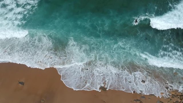 An aerial view of surfer in the ocean on a clear day. Surf Spot on the Portuguese coastline.