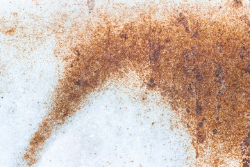 A close-up of rust on a white metal plate. Abstract background texture