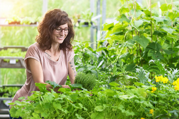 Frau im Gartencenter freut sich über einen Topf frischen Thymian