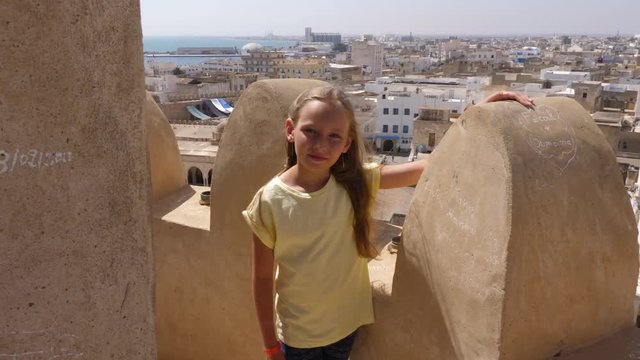 Girl standing in Ribat fortress in Sousse city on city panorama background