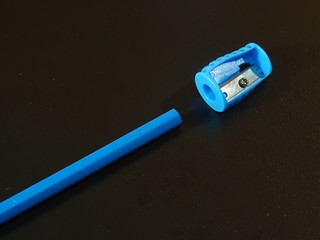 A blue pencil and a sharpener on a dark. Part 1