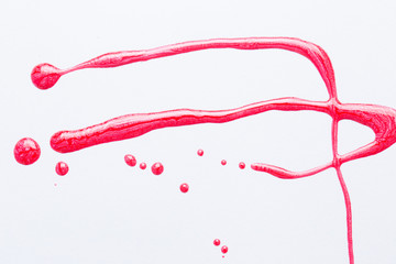 Nail polish on a white background in the form of strips and drops