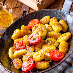gnocchi baked with green pesto, cherry tomatoes and parmesan