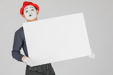happy MIME artist holding a blank white Board, on a white background.