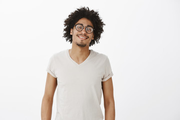 Good-looking confident and carefree man with afro haircut and moustache in trendy glasses with...