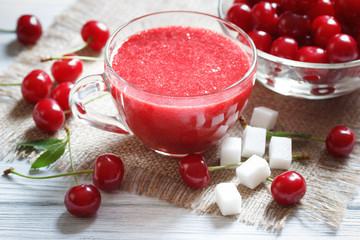 Tasty sweet smoothie cherry drink in glass cup on table
