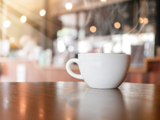 A cup of espresso coffee on wooden table in the background of cafeteria